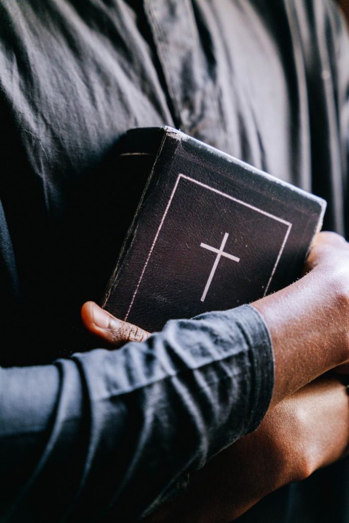 persons hugging a bible
