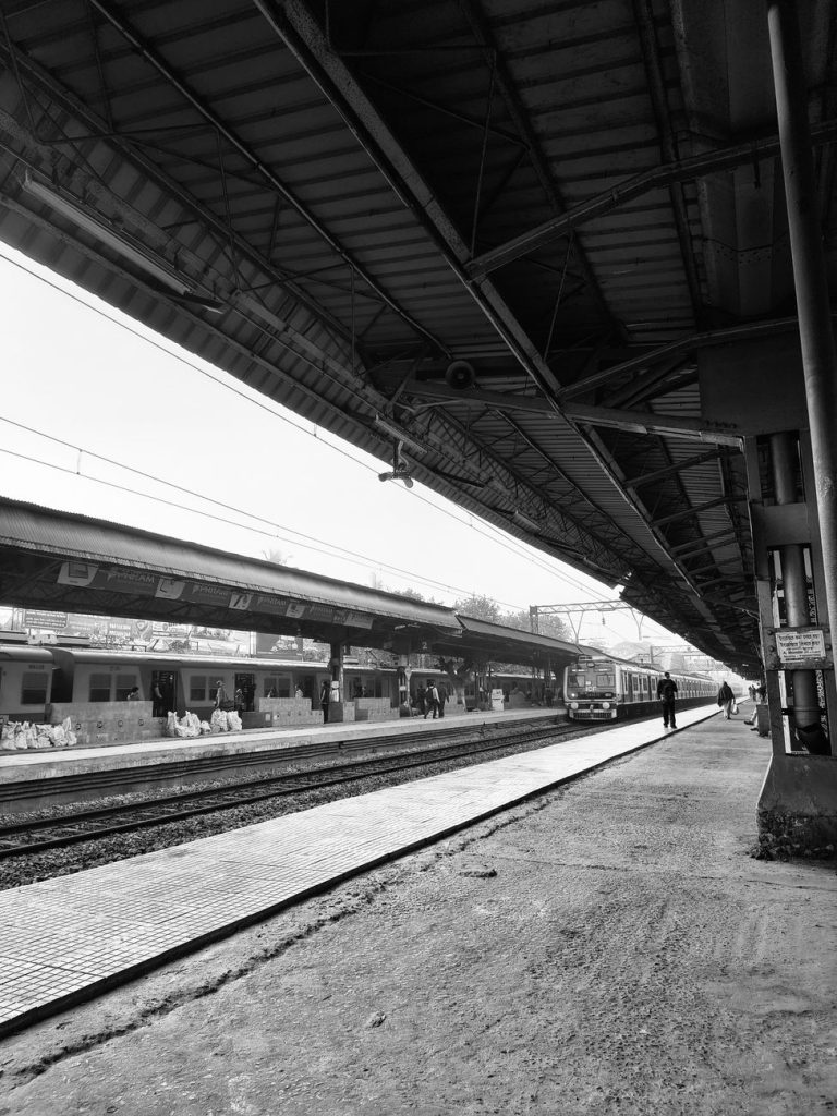 black and white train station with platform view