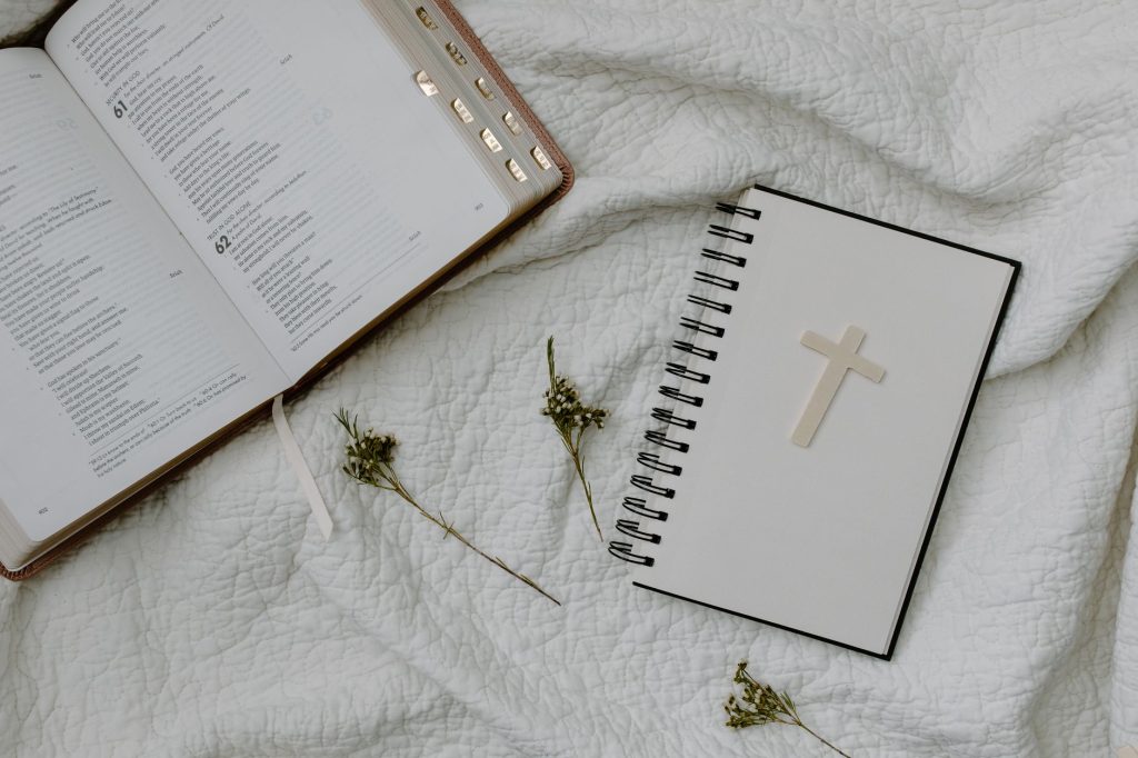a book and a notebook on the white textile